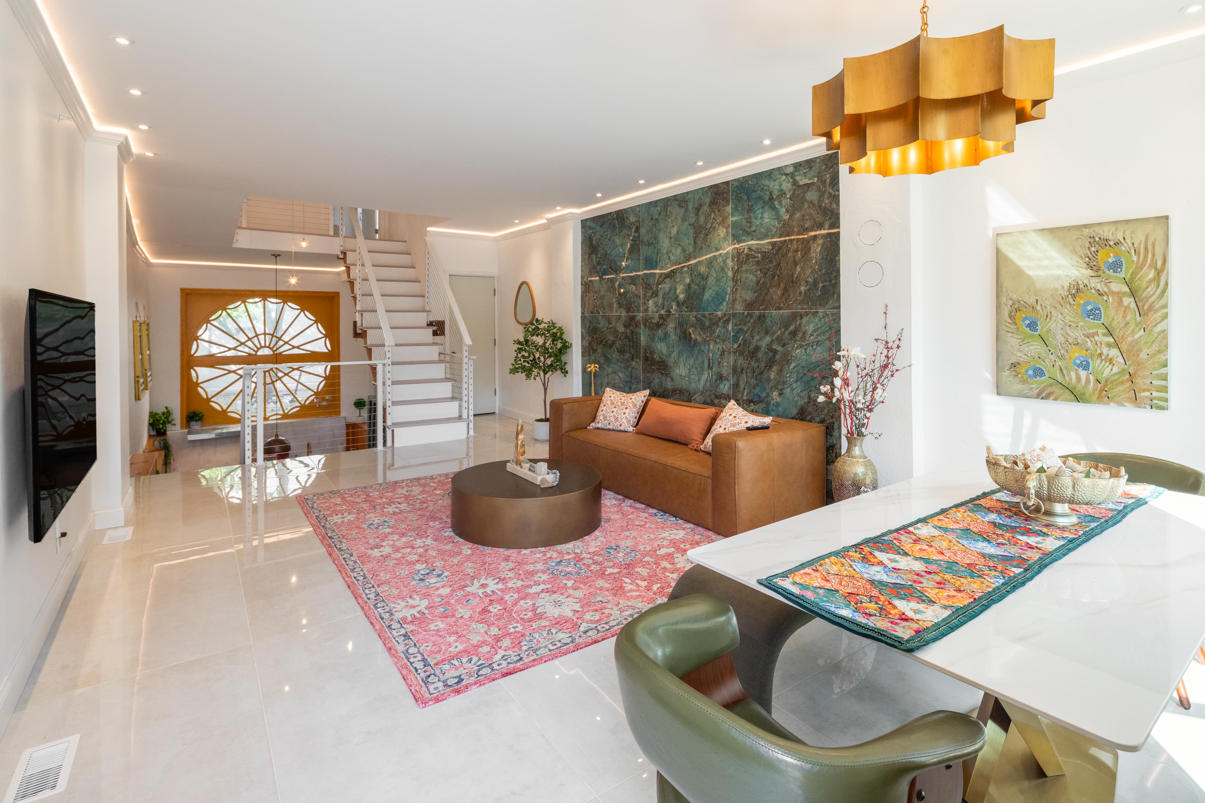 Bright and modern living room featuring a leather sofa, decorative rug, and stylish lighting.